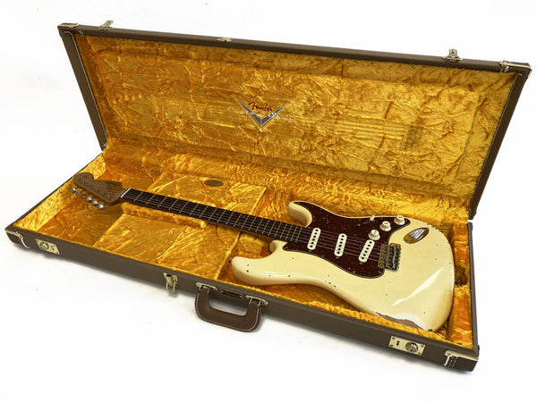 Vintage Fender Stratocaster electric guitar with white finish and tortoiseshell pickguard in original yellow plush-lined brown Fender case