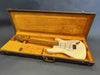 Vintage cream Fender Stratocaster electric guitar with maple neck and fretboard in an open brown hard case with orange plush interior lining