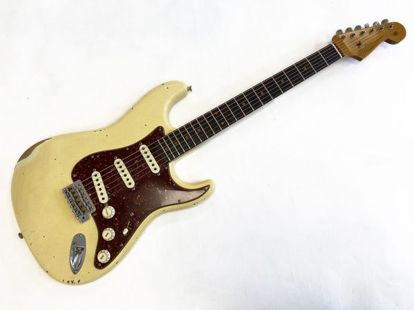 Vintage Fender Stratocaster electric guitar with worn off-white body and tortoiseshell pickguard, maple neck, and rosewood fretboard.