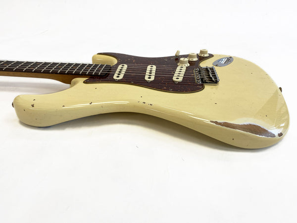 Vintage cream electric guitar with tortoiseshell pickguard and three single-coil pickups showing worn and relic finish on body