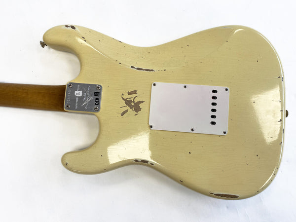 Vintage cream electric guitar body with worn paint and a white backplate, showing signs of heavy use and aging, neck plate with serial number and Fender logo on a white background.
