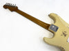 Back view of vintage cream Fender Stratocaster electric guitar with maple neck and tuning pegs, showing aging and wear marks on body and neck plate with serial number and Fender logo.
