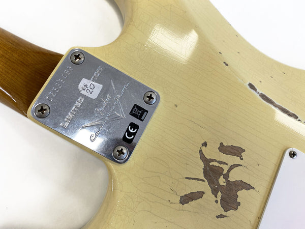Close-up of Fender Custom Shop Limited Edition metal neck plate and worn cream electric guitar body showing wood grain and finish wear.