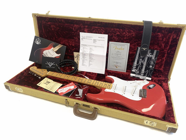 Fender Custom Shop 60th Anniversary Stratocaster in red with maple neck and white pickguard, displayed in open tweed hard case with red plush interior, accessories including certificate of authenticity, owner's manual, Fender Custom Care card, strap, and guitar cable.