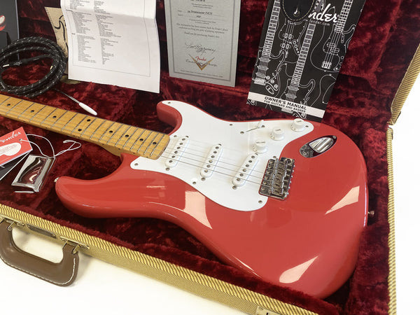 Fender Stratocaster NOS 2011 electric guitar in Fiesta Red finish with maple neck and white pickguard, displayed in tweed hard case with red plush interior, including Fender owner's manual and certificate of authenticity.