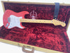 Fender Stratocaster 60th Anniversary electric guitar in Fiesta Red color with maple neck and fingerboard, displayed in a vintage tweed hard shell case with red plush interior and black leather Fender guitar strap.