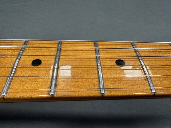 Close-up of guitar maple fretboard with metal frets and six steel strings on dark background