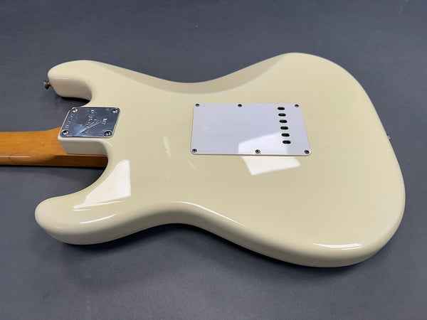 Back view of white electric guitar body with maple neck and metal neck plate on gray background