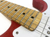 Close-up photo of guitar neck and fretboard with metal frets and strings on red and white electric guitar from Coffee House Guitars