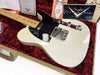 Fender Custom Shop vintage style white electric guitar with black pickguard, maple neck, and chrome hardware displayed in red velvet lined case with Fender certificates and booklet.