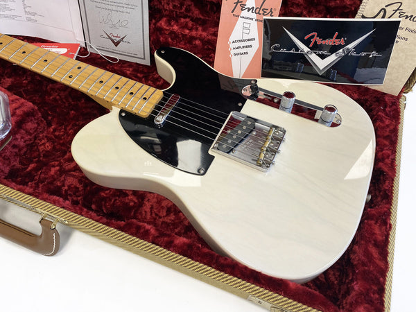 Fender Custom Shop vintage style white electric guitar with black pickguard, maple neck, and chrome hardware displayed in red velvet lined case with Fender certificates and booklet.