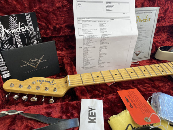 Fender Custom Shop right-hand 1951 Nocaster NOS guitar headstock and maple fretboard, certificate of authenticity, Fender custom care booklet, sales order details, guitar strap, and caution tag on red plush case lining.