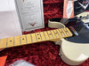 Close-up of Fender 1951 Nocaster NOS electric guitar with maple fretboard and black pickguard on red plush case lining, certificate of authenticity and Fender Custom Shop literature visible