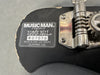 Close-up of Music Man Ernie Ball serial number X07578 label and tuning gear on guitar headstock showing manufacturing details from San Luis Obispo, California