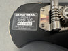 Close-up of Music Man Ernie Ball serial number X07578 label and tuning mechanism on black guitar body made in San Luis Obispo California USA with wear on edge