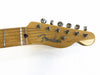 Close-up of Fender guitar headstock with tuning pegs and logo on natural wood finish against white background