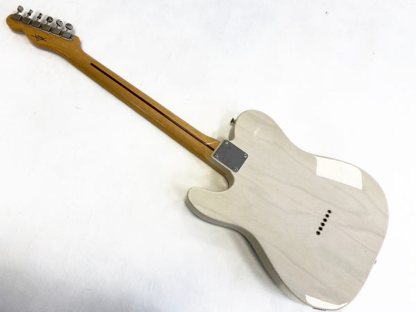 Back view of light-colored solid body electric guitar with maple neck and chrome tuning pegs on white background