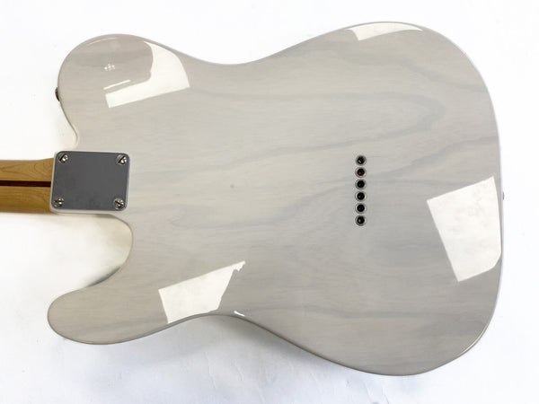 Glossy white electric guitar back with string ferrules and maple neck with a skunk stripe, showing smooth finish and wood grain.
