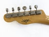 Back of Fender Custom Shop guitar headstock with six chrome tuning pegs on natural wood finish neck
