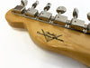 Close-up of Fender Custom Shop guitar headstock with vintage-style tuning machines on natural wood finish