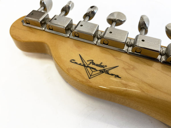 Close-up of Fender Custom Shop guitar headstock with vintage-style tuning machines on natural wood finish