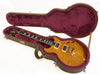Electric guitar with quilted maple top in a brown hard shell case lined with plush burgundy interior