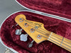 Fender Precision Bass headstock with four tuning pegs inside red velvet guitar case