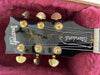 Gibson Standard Les Paul electric guitar headstock with gold tuning pegs on red plush case lining