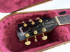 Gibson Les Paul Standard guitar headstock with gold tuning pegs inside pink plush-lined guitar case