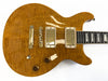 Honey burst electric guitar with quilted maple top, gold humbucker pickups, two control knobs, and toggle switch on light background