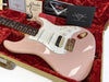 Fender Custom Shop electric guitar in pink with white pickguard and gold hardware, displayed in a red plush-lined case with Fender care booklets and certificates