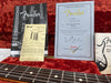 Fender Certificate of Authenticity for 1962 Stratocaster NOS guitar, Fender tremolo springs instruction sheet, owner’s manuals and guitar fretboard on red plush case lining