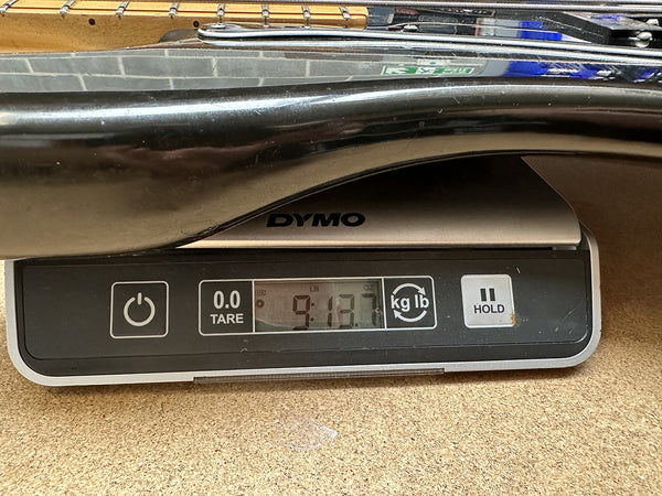 Close-up of a guitar body on a digital scale showing the weight as 9 pounds 13.7 ounces for Coffee House Guitars product listing.