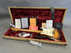 Vintage Fender Stratocaster electric guitar with sunburst finish in tweed hard case, including Fender certificate of authenticity, owner's manual, paperwork, accessories, and black leather guitar strap with white stitching