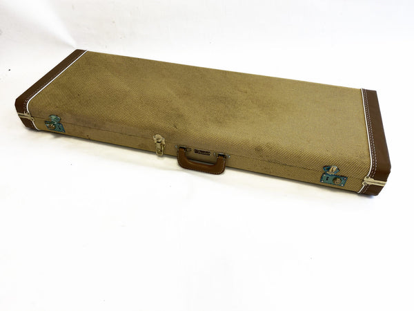 Vintage tweed guitar case with brown leather handle and corner reinforcements on white background