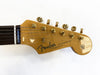 Close-up of Fender Stratocaster guitar headstock with gold tuning pegs and rosewood fretboard on white background