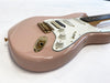 Pink electric guitar with white pickguard, gold hardware, and rosewood fretboard on white background