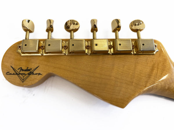 Back view of Fender Custom Shop guitar headstock with gold tuning pegs on natural wood finish