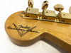 Close-up of Fender Custom Shop guitar headstock with vintage gold tuning machines and logo on natural wood finish