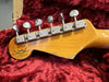 Close-up of Fender Custom Shop Limited Edition guitar headstock with vintage Kluson tuning pegs and natural wood finish on red plush guitar case lining