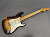 Vintage Fender Stratocaster electric guitar with sunburst finish and maple neck showing wear and aging