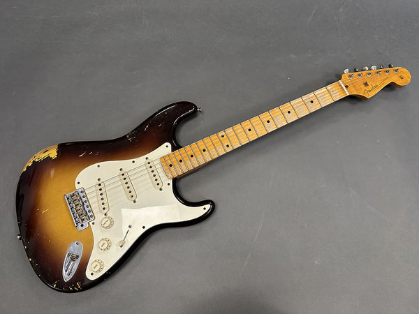 Vintage Fender Stratocaster electric guitar with sunburst finish and maple neck showing wear and aging