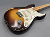 Vintage sunburst electric guitar with worn finish, three single-coil pickups, white pickguard, and maple neck on gray background