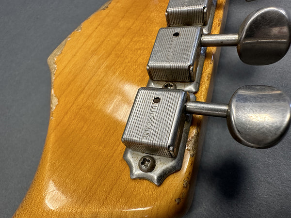 Close-up of vintage WIZARD tuning machines on worn wood guitar headstock with chipped finish