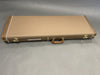 Brown Fender guitar hard case with white stitching and gold hardware on grey background
