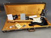 Fender electric guitar with maple neck and black body in brown hard case with orange interior, including Fender certificates and accessories