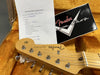 Close-up of Fender Stratocaster headstock in guitar case with Coffee House Guitars pre sales checklist and Fender Custom Shop sticker