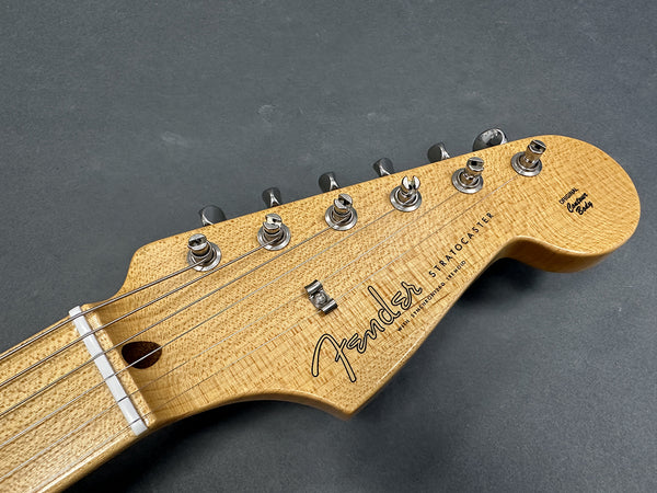Close-up of Fender Stratocaster Original Custom Body guitar headstock with tuning pegs and strings on gray background