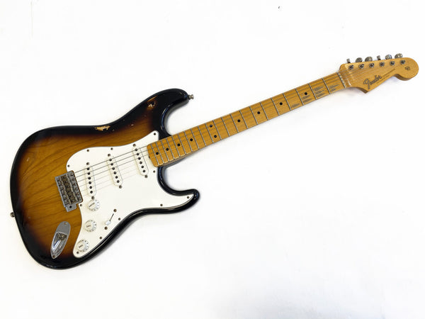 Vintage Fender Stratocaster electric guitar with sunburst finish and maple neck showing wear and aging