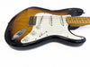 Vintage sunburst electric guitar body with white pickguard and maple neck showing wear and vintage style knobs
